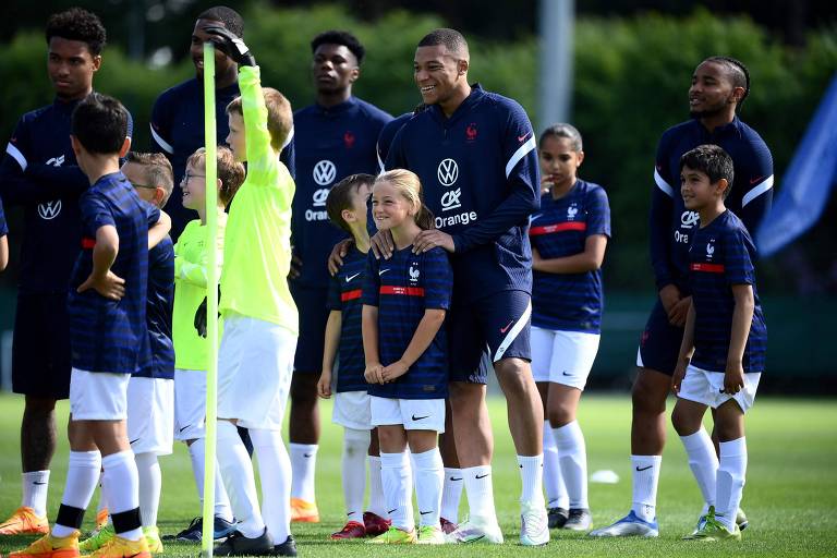 Mbappé (ao centro) e outros jogadores da seleção francesa confraternizam com crianças em Clairefontaine-en-Yvelines, local de formação de jogadores do país
