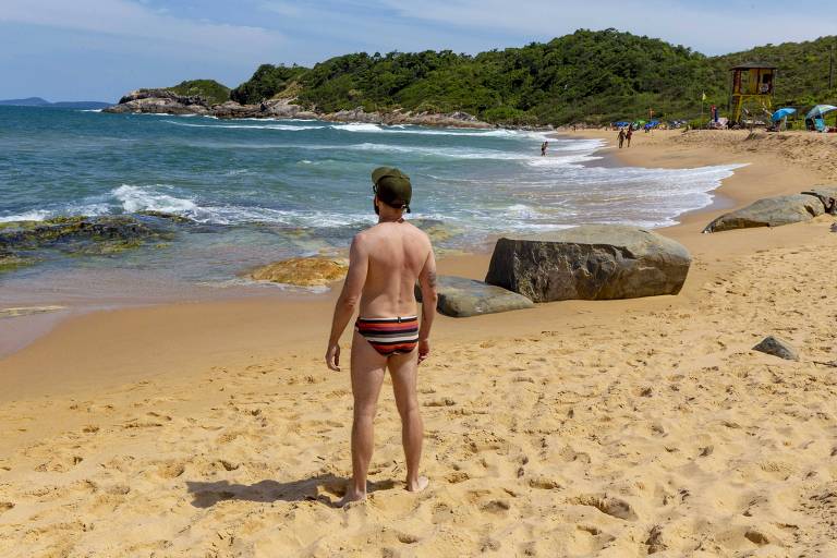 foto de homem de costas com sunga em praia