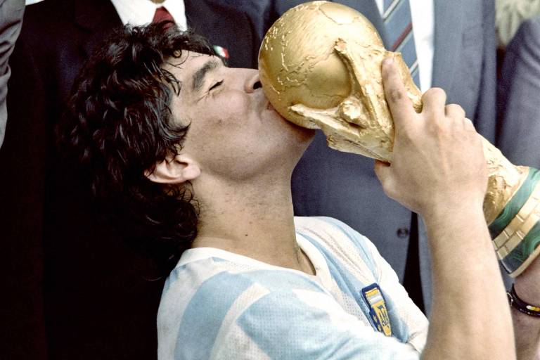 Maradona beija a Copa do Mundo conquistada em 1986 no México; foi a segunda taça da Argentina