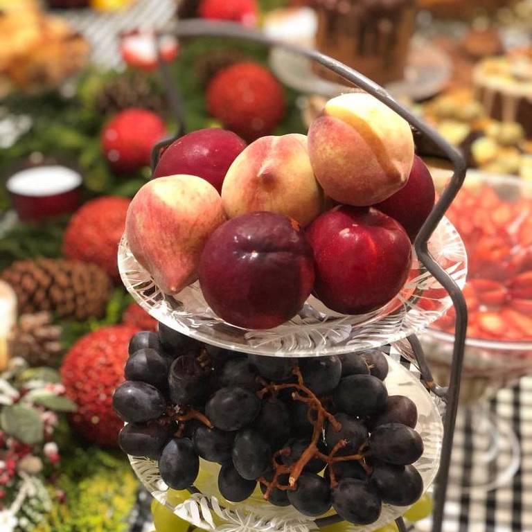 Mesa decorada para com Natal com pratos de dois andares com frutas