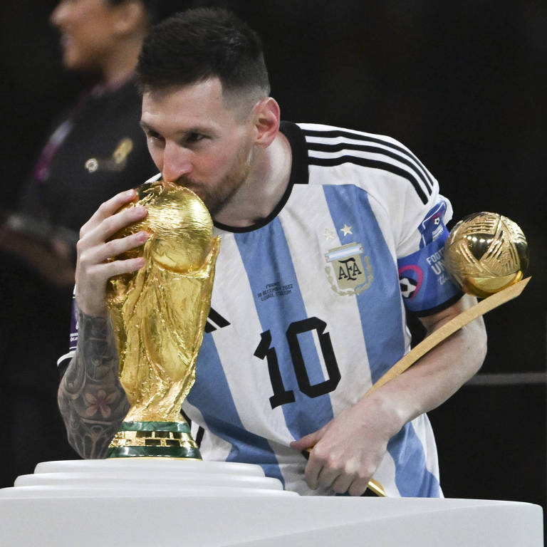 Com o troféu de melhor jogador da Copa do Qatar no braço, Messi beija o troféu do Mundial, a sua 42ª conquista na carreira