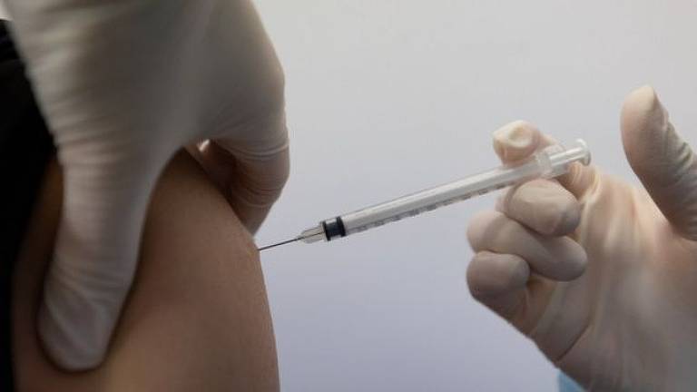 Foto destaca mão e braço durante aplicação de vacina