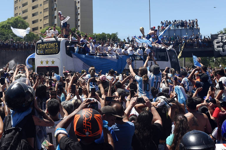 Milhares de torcedores da Argentina festejam o título da Copa do Qatar ao redor do ônibus que leva os tricampeões do mundo, complicando a passagem do veículo rumo ao centro de Buenos Aires