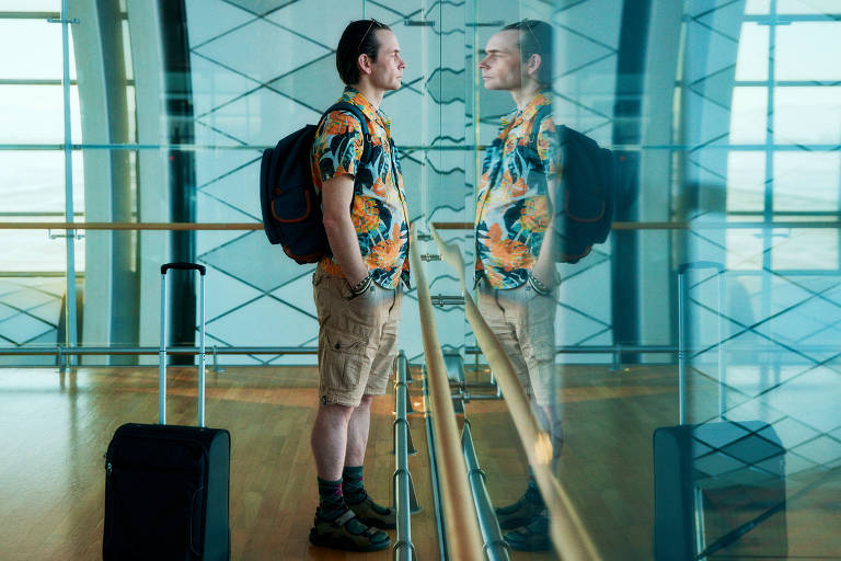 foto de um homem olhando para um vidro no aeroporto