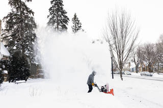 Snow is kicked up by a snowblower in Minneapolis, Minn. on Friday, Dec. 23, 2022. (Jenn Ackerman/The New York Times)