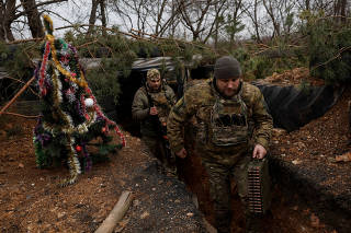 Ukrainian serviceman decorates a Christmas tree, in Bakhmut