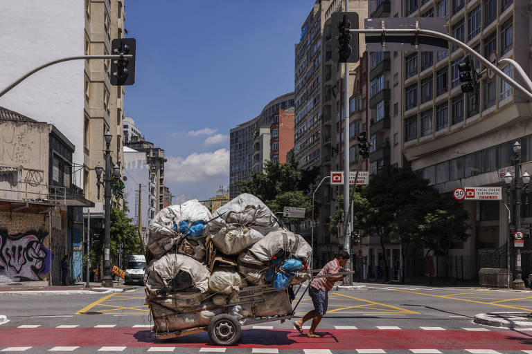 Catador puxa carroça carregada de material reciclável na avenida Duque de Caxias, na região central de São Paulo