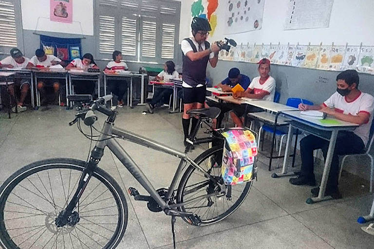 Sala de aula com alunos e bicicleta ao centro