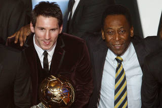 FILE PHOTO: Messi of Argentina, FIFA World Player of the Year holds his FIFA Ballon d'Or 2011 trophy next to Pele during the FIFA Ballon d'Or 2011 soccer awards ceremony in Zurich