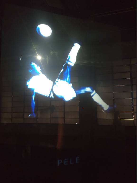 Com uniforme branco, Pelé dá uma bicicleta em imagem em 3D no Museu do Futebol, em São Paulo