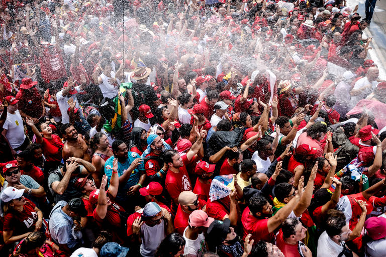 Bombeiros borrifam água para aliviar apoiadores do presidente eleito Luiz Inácio Lula da Silva do calor enquanto se reúnem para aguardar sua cerimônia de posse na praça "Tres Poderes", em frente ao Palácio do Planalto, em Brasília