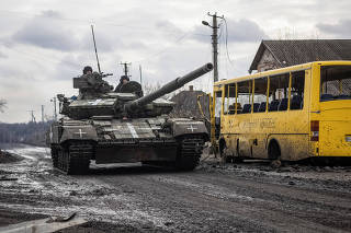 Ukrainian servicemen ride a tank in the village of Torske