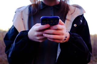 An adolescent uses their mobile phone, at home in Egan, Minn. on Oct. 28, 2021. (Annie Flanagan/The New York Times)