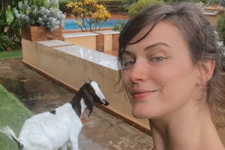 Em foto colorida, mulher mostra seu nome animal de estimação: uma cabra