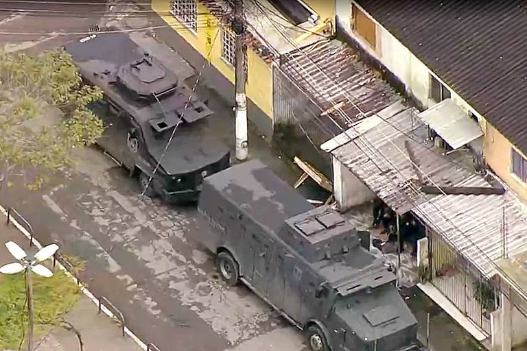 Imagem aérea mostra dois veículos blindados da Polícia Militar em rua do Rio de Janeiro