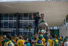 Supporters of Brazilian former President Jair Bolsonaro assist a Military Manifestantes ajudam um policial militar durante confronto