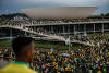 Supporters of Brazilian former President Jair Bolsonaro assist a Military Manifestantes ajudam um policial militar durante confronto