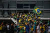 Supporters of Brazilian former President Jair Bolsonaro assist a Military Manifestantes ajudam um policial militar durante confronto