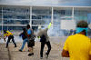 Supporters of Brazilian former President Jair Bolsonaro assist a Military Manifestantes ajudam um policial militar durante confronto