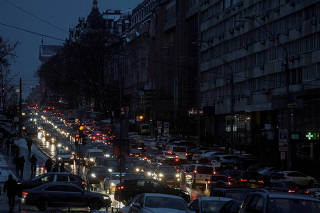 FILE PHOTO: Cars are seen on a street during a power blackout after critical civilian infrastructure was hit during Russian missile attacks in Kyiv