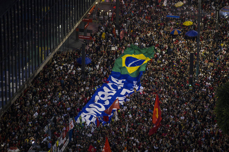 Manifestantes carregam faixa e bandeira do Brasil