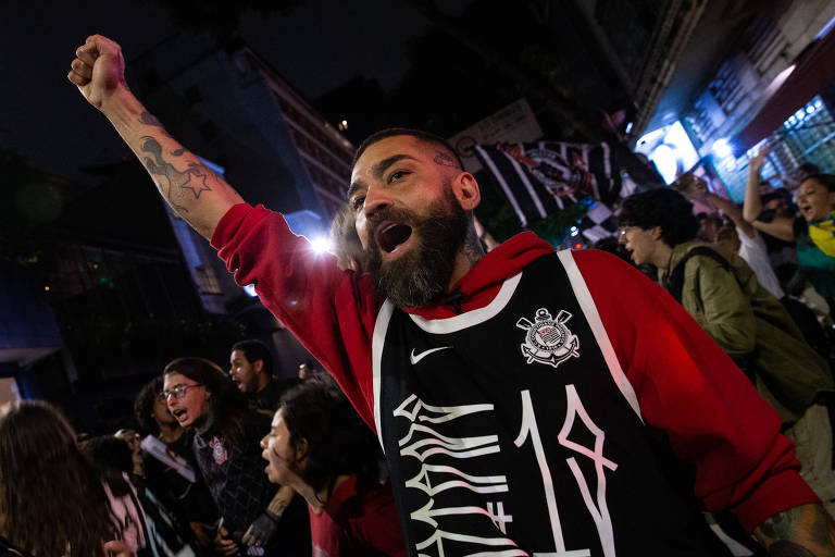 Torcedor do Corinthians ergue o punho em ato na Paulista contra o golpismo; avenida recebeu também torcidas organizadas de São Paulo, Palmeiras e Santos
