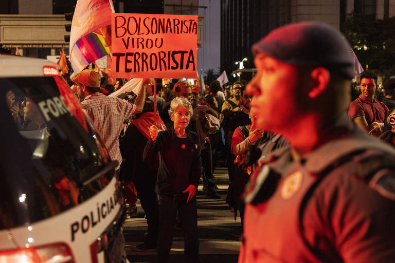 Policial militar diante de manifestantes em ato pela democracia na avenida Paulista