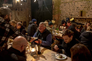 Culinary class attendees eat a meal of foods that they have butchered and foraged on site at Firle Estate in East Sussex, England on Nov. 12, 2022. (Andrew Testa/The New York Times)