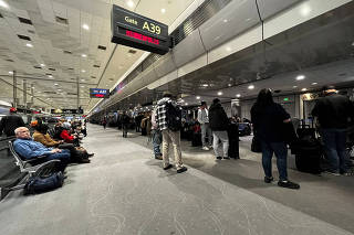 People wait at Denver International Airport, as flights were grounded after FAA system outage, in Denver