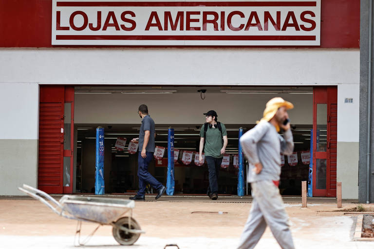 pessoas diante de uma loja de fachada vermelha e branca em que se lê Lojas Americanas