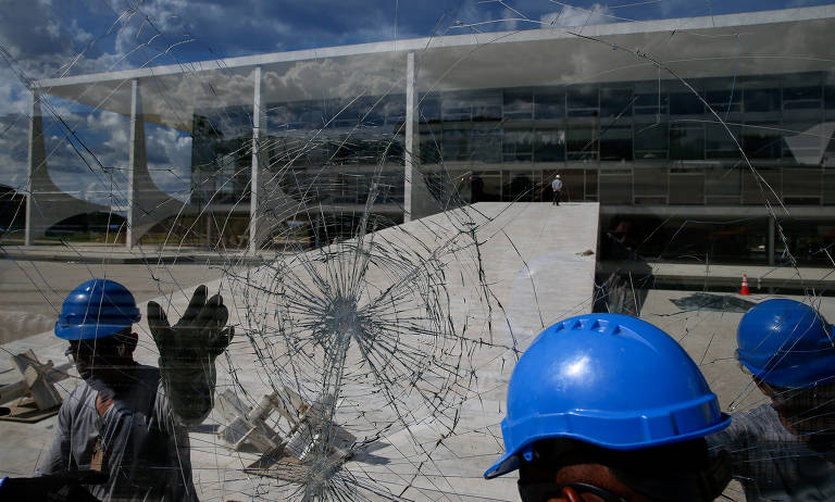 Funcionários do Palácio do Planalto retiram vidros que foram quebrados  durante a invasão do protesto golpista