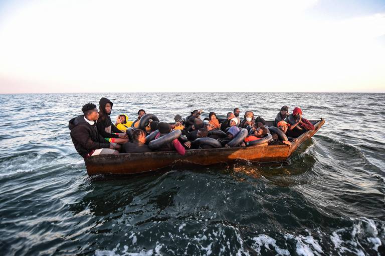 Migrantes em barco clandestino a caminho da costa italiana, no Mar Mediterrâneo
