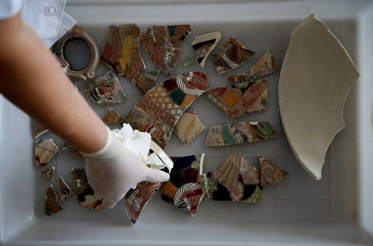 Cacos de cerâmica de vasos chineses são recolhidos por restauradora