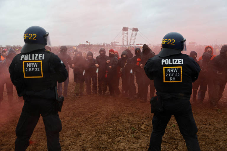 Ativistas se reúnem em meio à fumaça colorida durante protesto contra expansão de mina na Alemanha