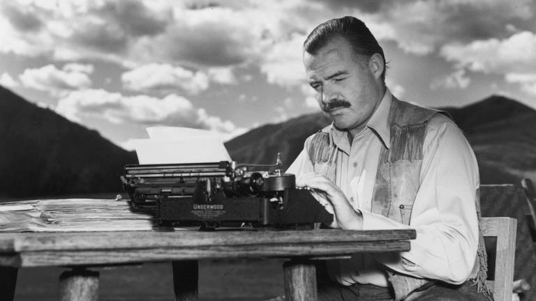 O escritor Ernest Hemingway tendo ao fundo o Kilimanjaro