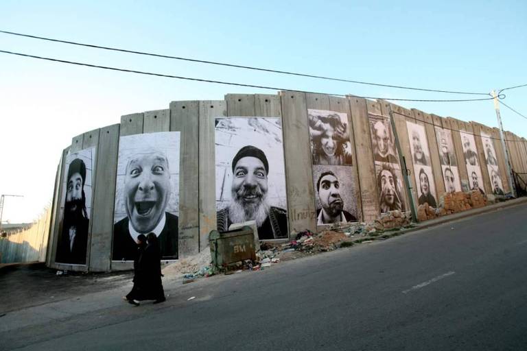 JR, retratos de palestino e israelenses juntos no muro, exclusivo entretempos