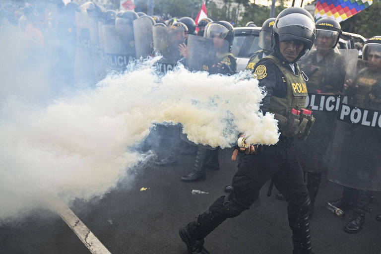 Policial segura bomba de gás durante protesto contra Dina Boluarte em Lima, no Peru