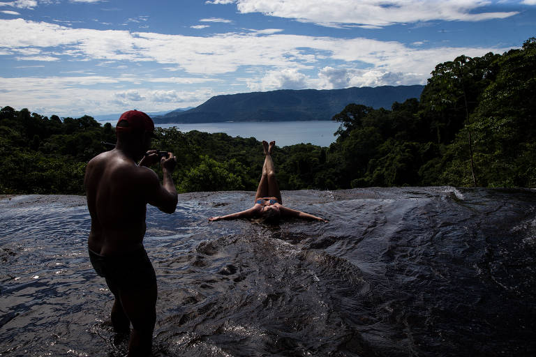 Ana Ferragut Cardoso, 37, faz a pose da sereia na cachoeira do Paquetá, em Ilhabela