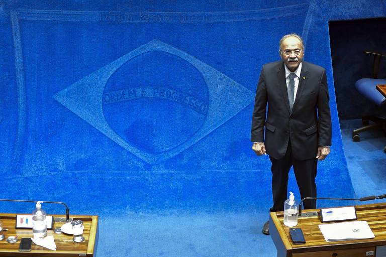 O senador Chico Rodrigues aparece de pé no plenário do Senado Federal ao lado da bandeira do Brasil desenhada no carpete azul 