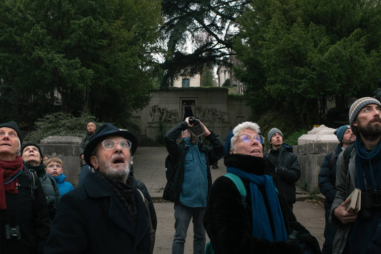 Pessoas participam de um passeio de observação de pássaros no cemitério Père-Lachaise, em Paris