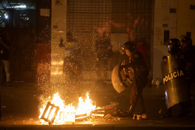 Policiais próximos a barricadas incendiadas durante manifestações antigoverno em Lima, no Peru