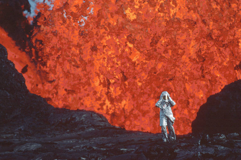 A vulcanóloga Katia Krafft com trajeto protetor de alumínio em frente a uma explosão de lava no vulcão Krafla, na Islândia. A vida dela e seu marido, Maurice Krafft, também vulcanólogo, são retratados no documentário 'Fire of Love', de Sara Dosa