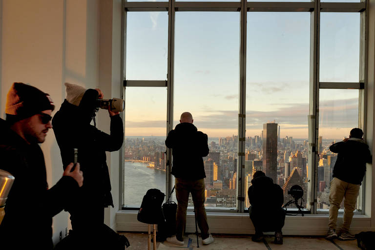 Photographers with social media followings at sunrise at Sutton Tower in New York, Nov. 29, 2022. Developers are teaming up with niche influencers who trade targeted posts for entry into luxury residential buildings. (Gabby Jones/The New York Times)