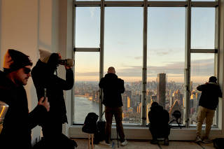 Photographers with social media followings at sunrise at Sutton Tower in New York, Nov. 29, 2022. (Gabby Jones/The New York Times)