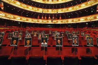 Photographs of guests who will attend the BAFTA awards ceremony are displayed on seats at the Royal Opera House in London