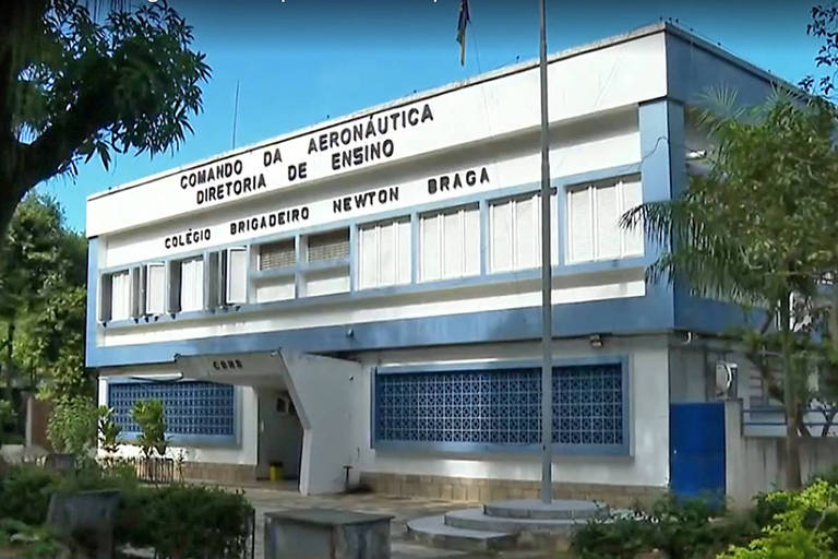 Imagem colorida mostra fachada do Colégio Brigadeiro Newton Braga, na Ilha do Governador, zona norte do Rio. Na foto, há um prédio branco em detalhes na cor azul, e árvores ao redor.