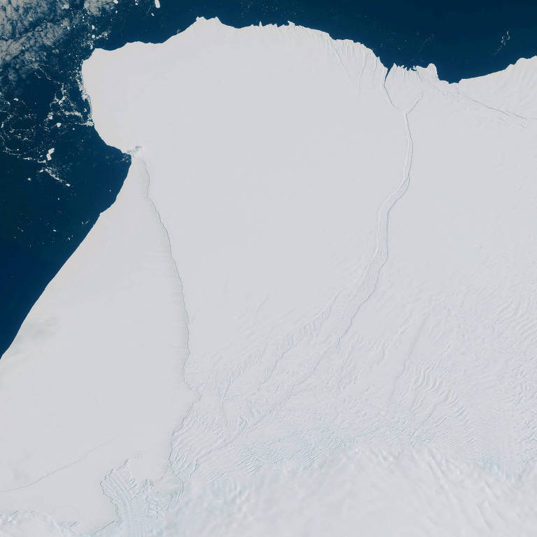 Plataforma de gelo é vista de cima ainda inteira, toda branca sobre o mar azul escuro, antes de rompimento de iceberg