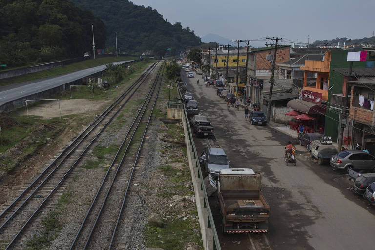 Linha férrea na beira da rodovia dos Imigrantes, com a Vila Esperança, em Cubatão (SP), ao lado