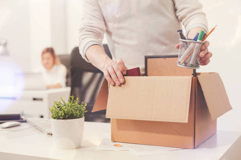Nothing left behind. Attentive dedicated fired man packing his stuff in a box as he cleaning his workplace before leaving the office.Credito AdobeStock