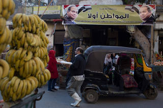 Egyptians walk at a popular market in Cairo